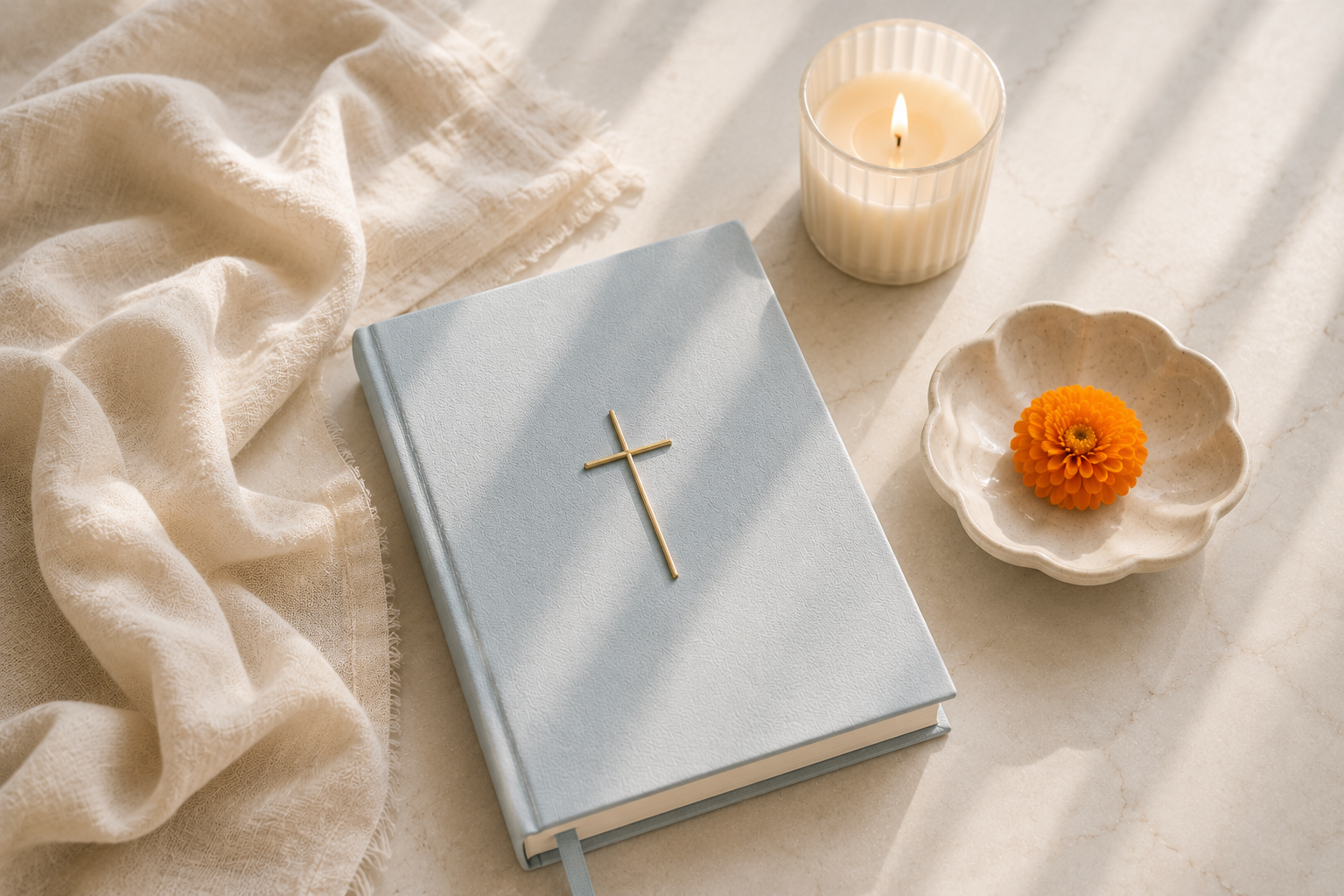 A softly styled flat-lay of a laptop, candle, journal, and design mood boards